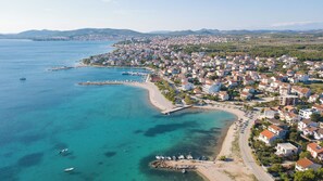 An aerial view of a coastal town with a marina, sandy beaches, and residential buildings. - Apartment Lily With Pool Srima (Vodice)