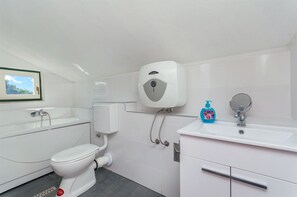A modern bathroom with a toilet, sink, and hand dryer. - House Merica (Trogir)