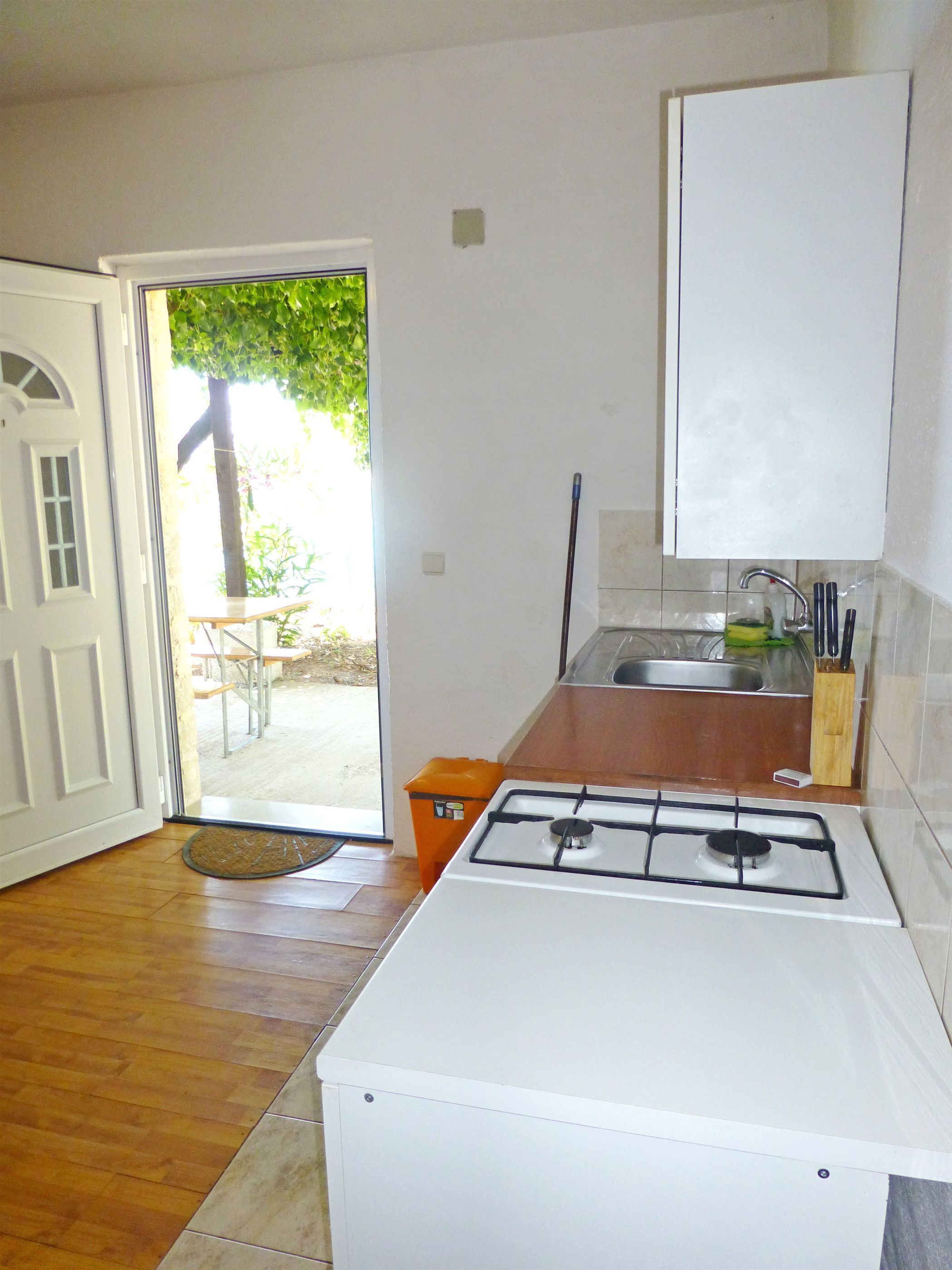 A compact kitchen with a gas stove, a sink, and a small countertop.