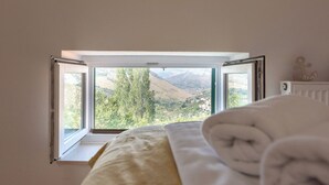 A bedroom with a window view of a mountainous landscape. - House Marinka (Split)