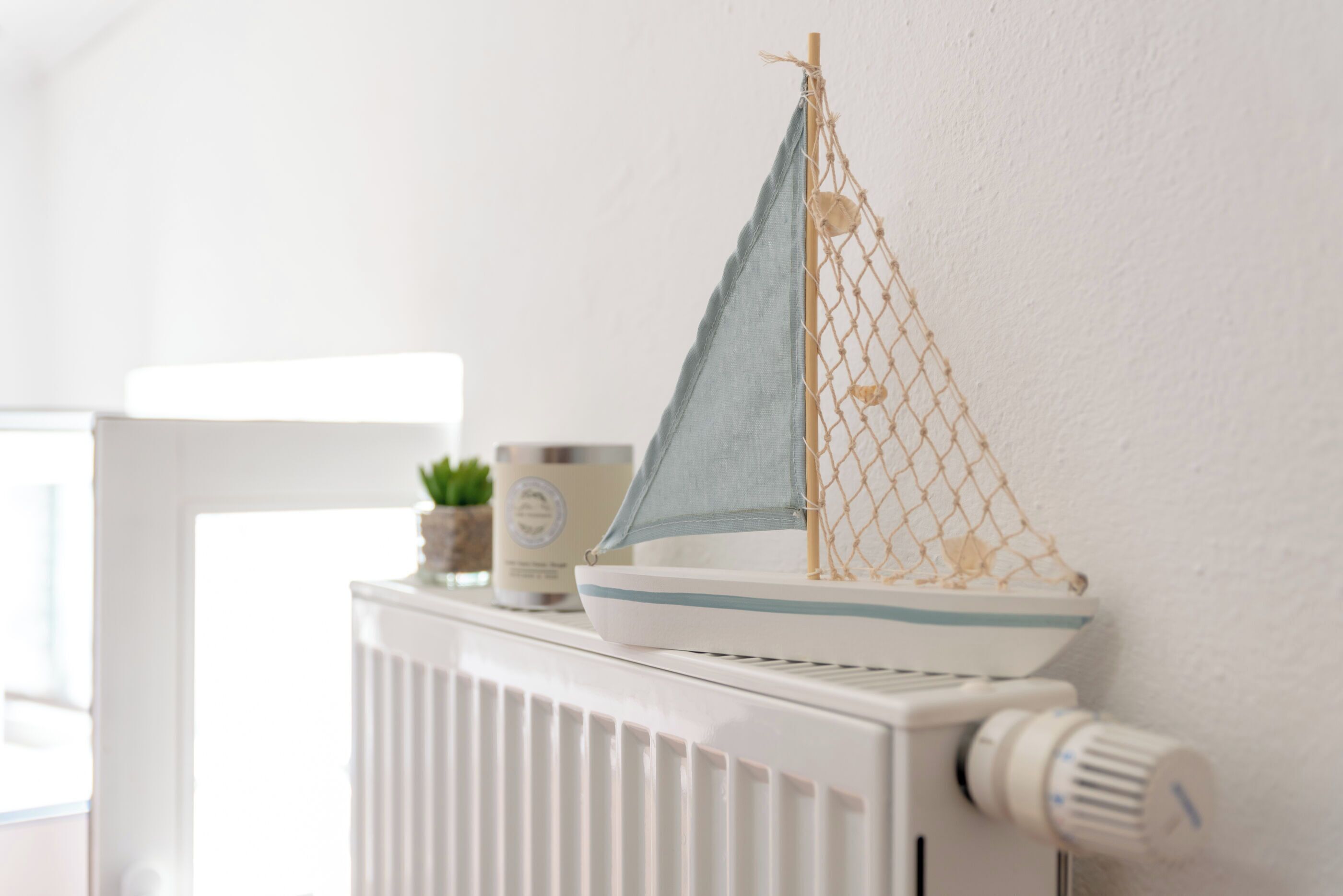 Een model zeilboot op een radiator.