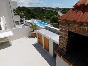 Eine Dachterrasse mit Pool, einem Topfpflanzen und einem Backofen.