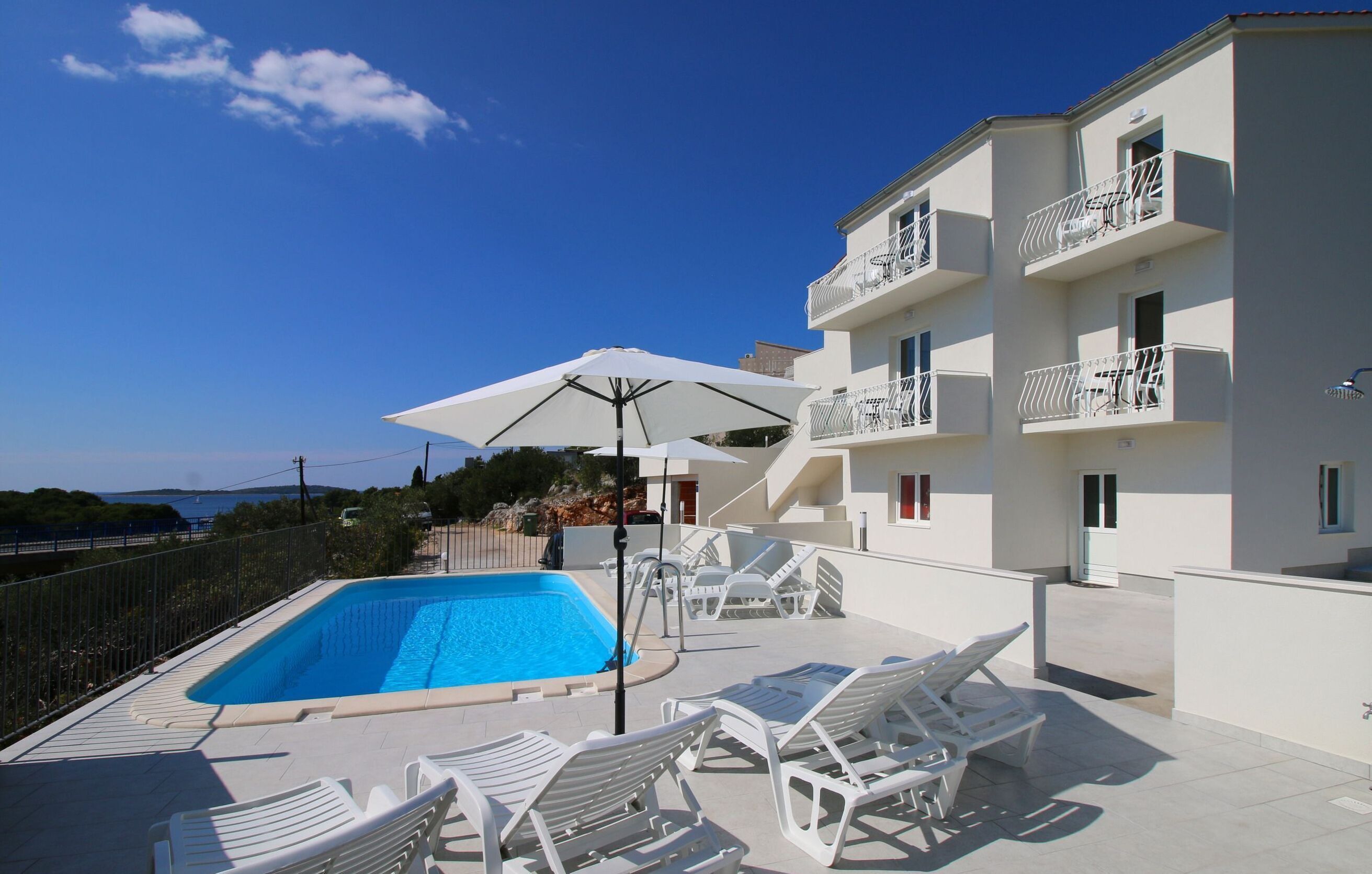 Una piscina al aire libre, sombrillas, tumbonas