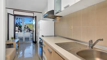 Appartement (A10) | Privékeuken | Een koelkast, kookgerei, borden en bestek