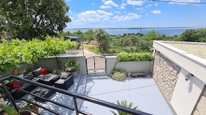A balcony with outdoor seating, a gate, and a view of the sea. - House Ante (Starigrad)