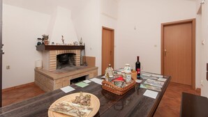 Ein Zimmer mit Kamin, einem Esstisch mit diversen Gegenständen und zwei Holztüren.
