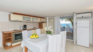 Een moderne keuken met een eethoek, een koelkast en uitzicht op zee.