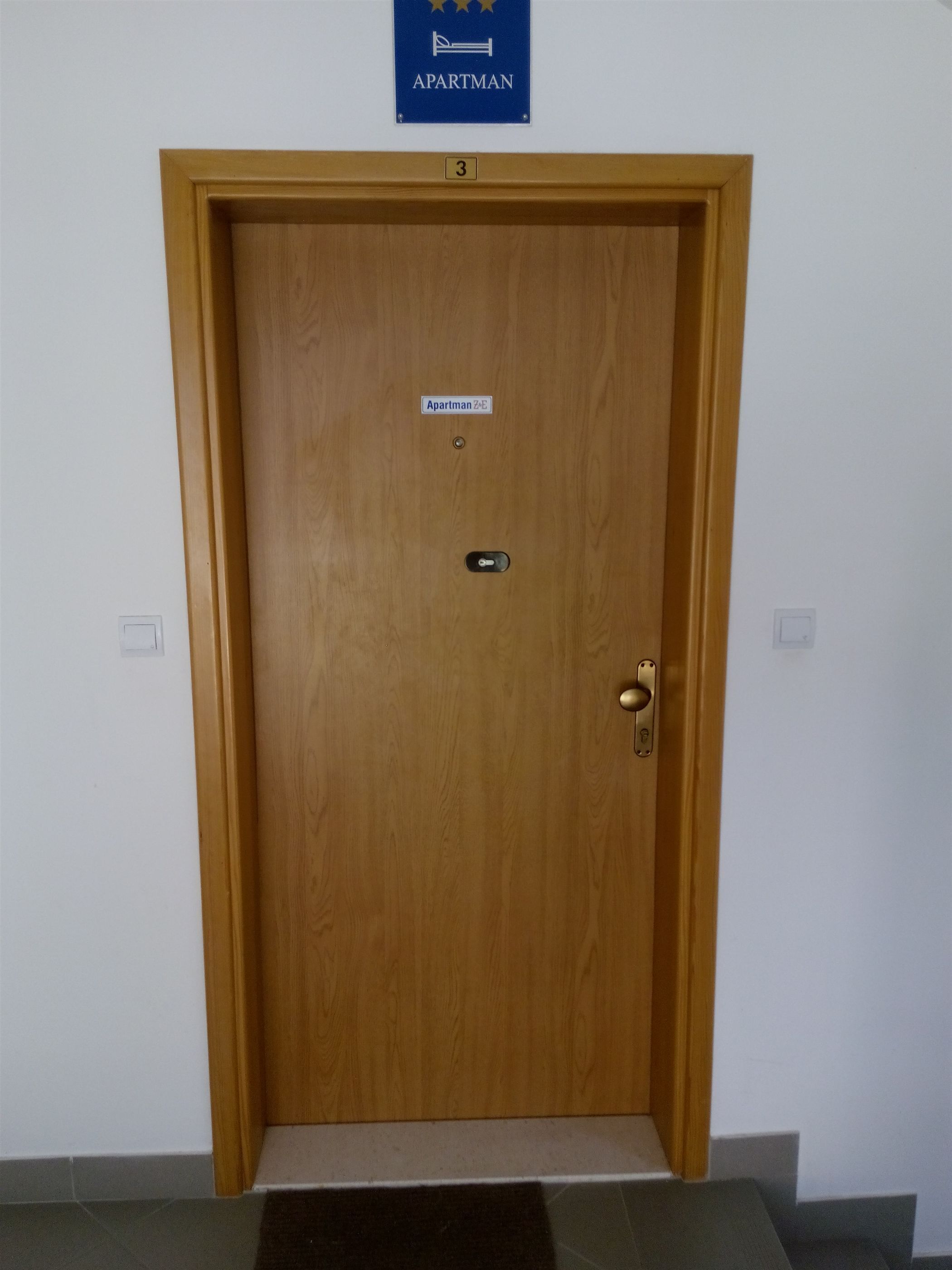 Uma porta de madeira com uma placa indicando que é um apartamento.