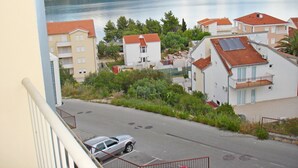 Ein Wohngebiet mit Gebäuden, einer Straße und einem Gewässer im Hintergrund.
