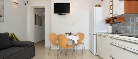 A modern kitchen with white cabinets, a built-in oven, and a tiled backsplash.