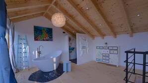 A spacious bathroom with a freestanding bathtub, a large mirror, and a wooden ceiling. - House Bjankura (Smokvica)