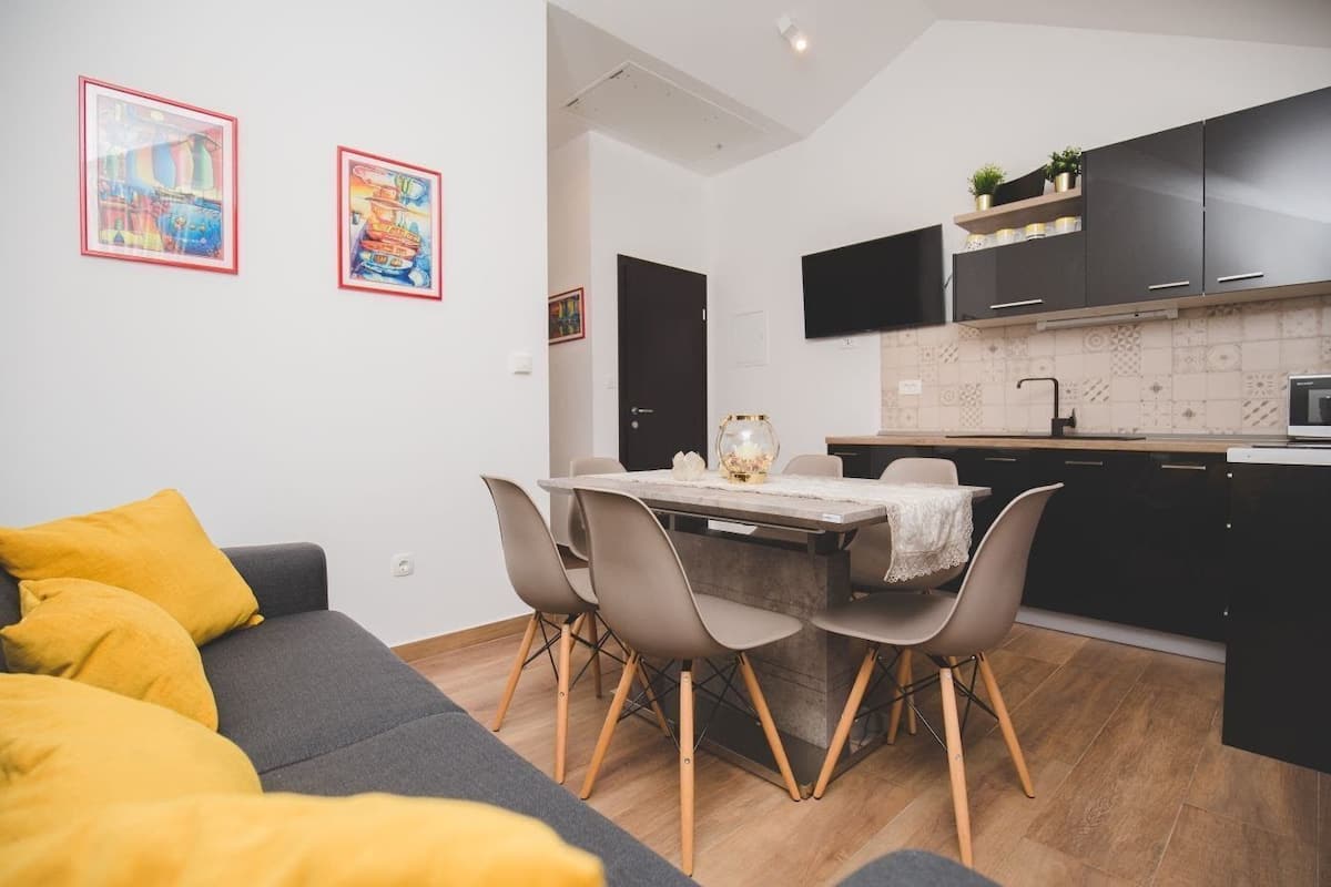 Un appartement moderne comprenant un coin repas, une cuisine et un salon.
