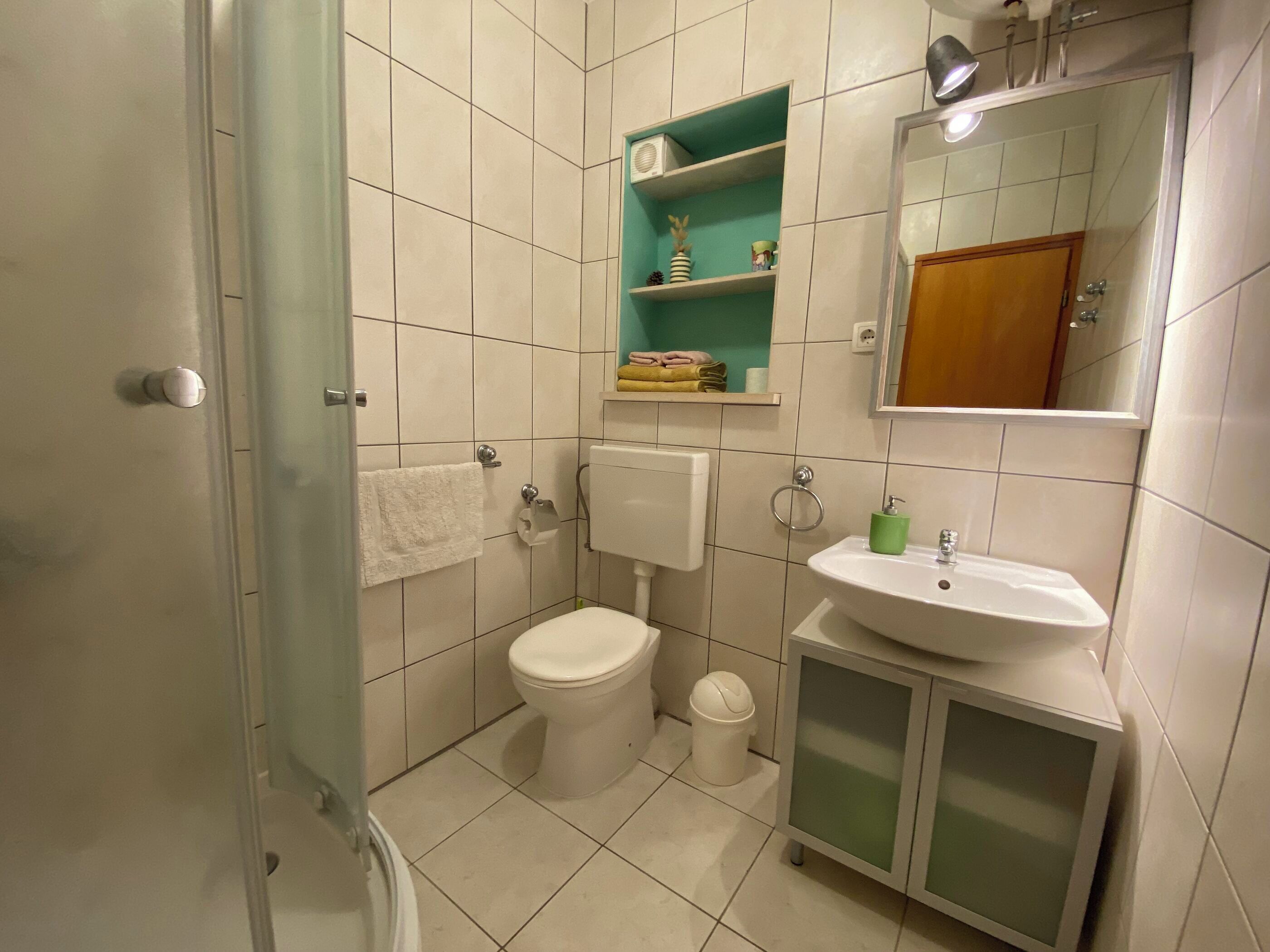 Un baño con inodoro, lavabo y espejo.
