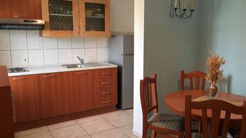 Una cocina con gabinetes de madera, una campana extractora de acero inoxidable y salpicadero de azulejos.