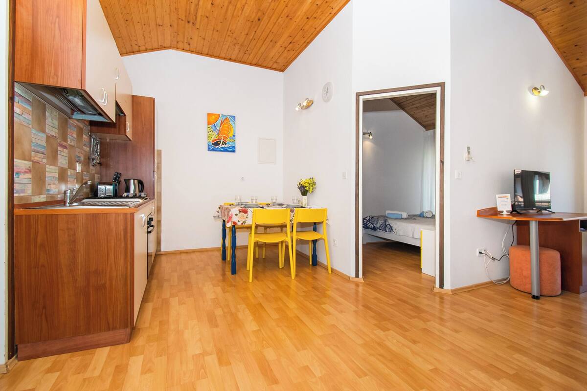 A compact living space with a kitchen, dining area, and a bedroom.