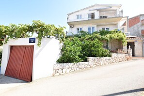 Un edificio con un muro de piedra, una puerta roja y un cartel que dice "ULICA PLAT".