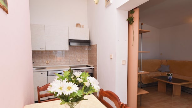Un espacio habitable compacto con comedor, kitchenette y sofá en la sala.