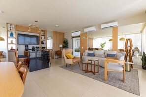 Ein modernes Wohnzimmer mit Sofa, Couchtisch und Essbereich.
