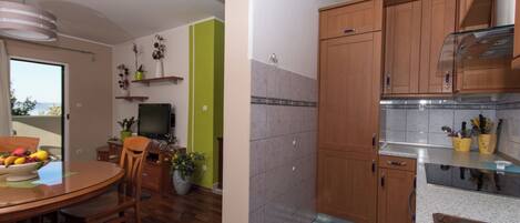 A modern kitchen with wooden cabinets, a stainless steel sink, and a dining area with a round table and chairs.