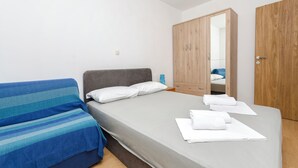 A bedroom with a bed, a wardrobe, and a bedside table. - Apartment Milena (Vodice)