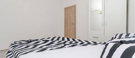 A bedroom with a bed, a wardrobe, and a door.