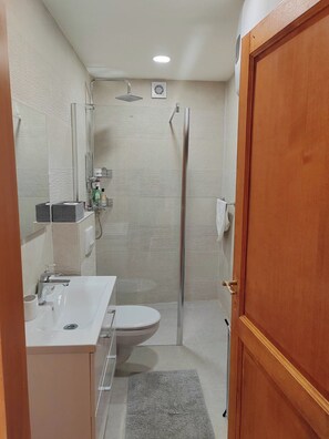 Un bagno piccolo ma funzionale, con toilette, lavabo e doccia.