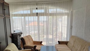 Ein Wohnzimmer mit einer Couch, zwei Sesseln, einem Couchtisch und einem Schrank.
