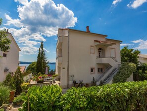 A two-story building with a balcony, a staircase, and a view of the sea. - Apartments Vanessa (Crikvenica)