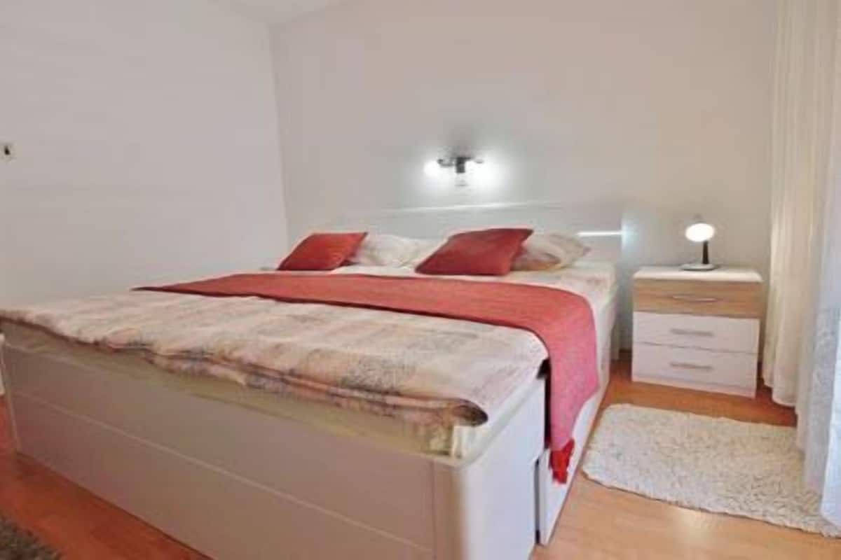 Ein Schlafzimmer mit Bett, Nachttisch und Beistelltisch.