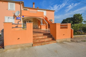 A building with a stone archway entrance, a staircase leading to the entrance, and a satellite dish on the wall. - Apartments Mihaela (Pasman)