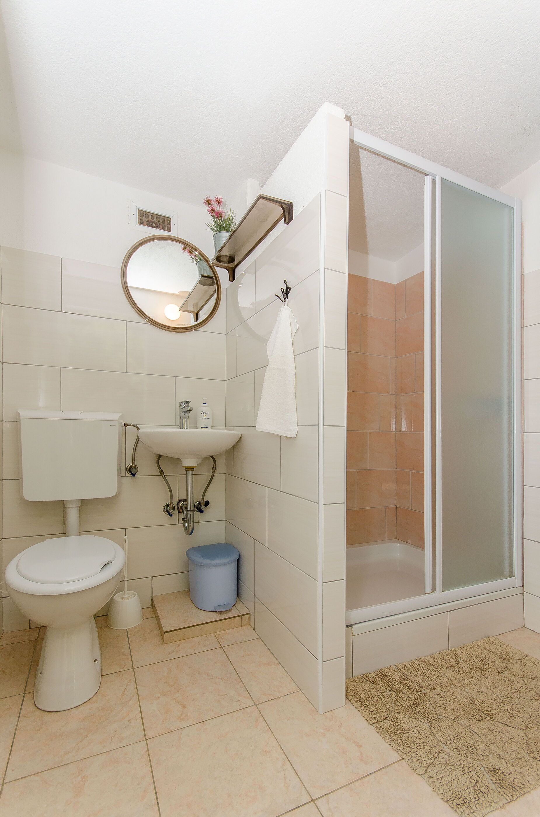 A bathroom with a toilet, sink, and shower.