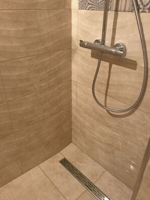 A shower area with a handheld showerhead and a wall-mounted faucet. - Apartment Milivoj (Primosten)
