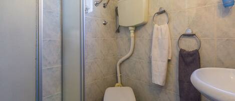 Un baño con ducha, inodoro y lavamanos.