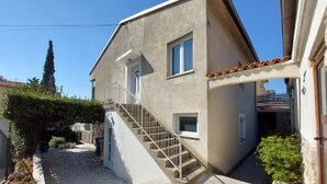 Une maison à deux étages avec un escalier en pierre menant à l’étage supérieur.