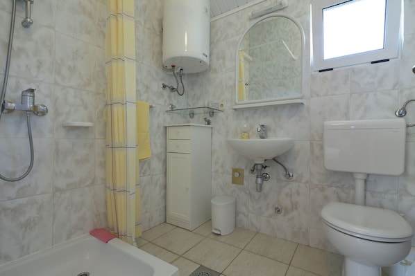 A bathroom with a bathtub, toilet, sink, and shower. - Apartment Martina (Jelsa)