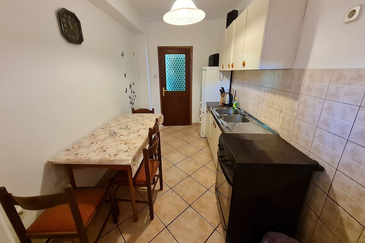 Une cuisine de taille réduite comprenant une table à manger, des chaises, une cuisinière et un évier.