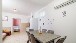 Una cocina moderna con refrigerador, una mesa de comedor con sillas y una isla de cocina.