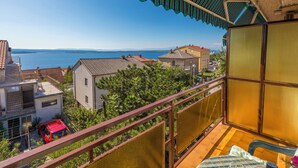 Un balcone con vista sul mare e sugli edifici.
