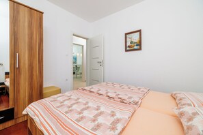 Ein Schlafzimmer mit einem Bett, einem Kleiderschrank, einer Tür zu einem anderen Raum und einem Bild an der Wand.