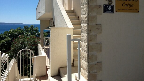 A building with a stone facade, a staircase, and a sign indicating '38 Apartments Caciga'. - Apartments Cacija (Okrug)