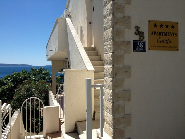 A building with a stone facade, a staircase, and a sign indicating '38 Apartments Caciga'. - Apartments Cacija (Okrug)