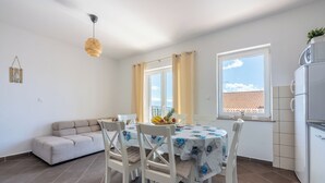 Eine moderne Küche mit Essbereich, weißen Möbeln und Blick auf die Stadt.