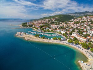 A coastal town with a marina, beach, and residential buildings. - Apartments Luna (Crikvenica)