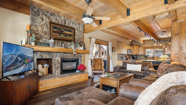 Ein gemütliches Wohnzimmer mit Kamin, Fernseher und einer großen Couch.