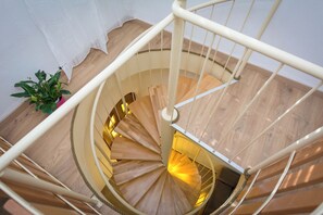 Un escalier en colimaçon avec des marches en bois et une rampe blanche.