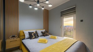 A modern bedroom with a bed, bedside tables, a ceiling light fixture, and a window with a view. - Apartments Marijana (Crikvenica)