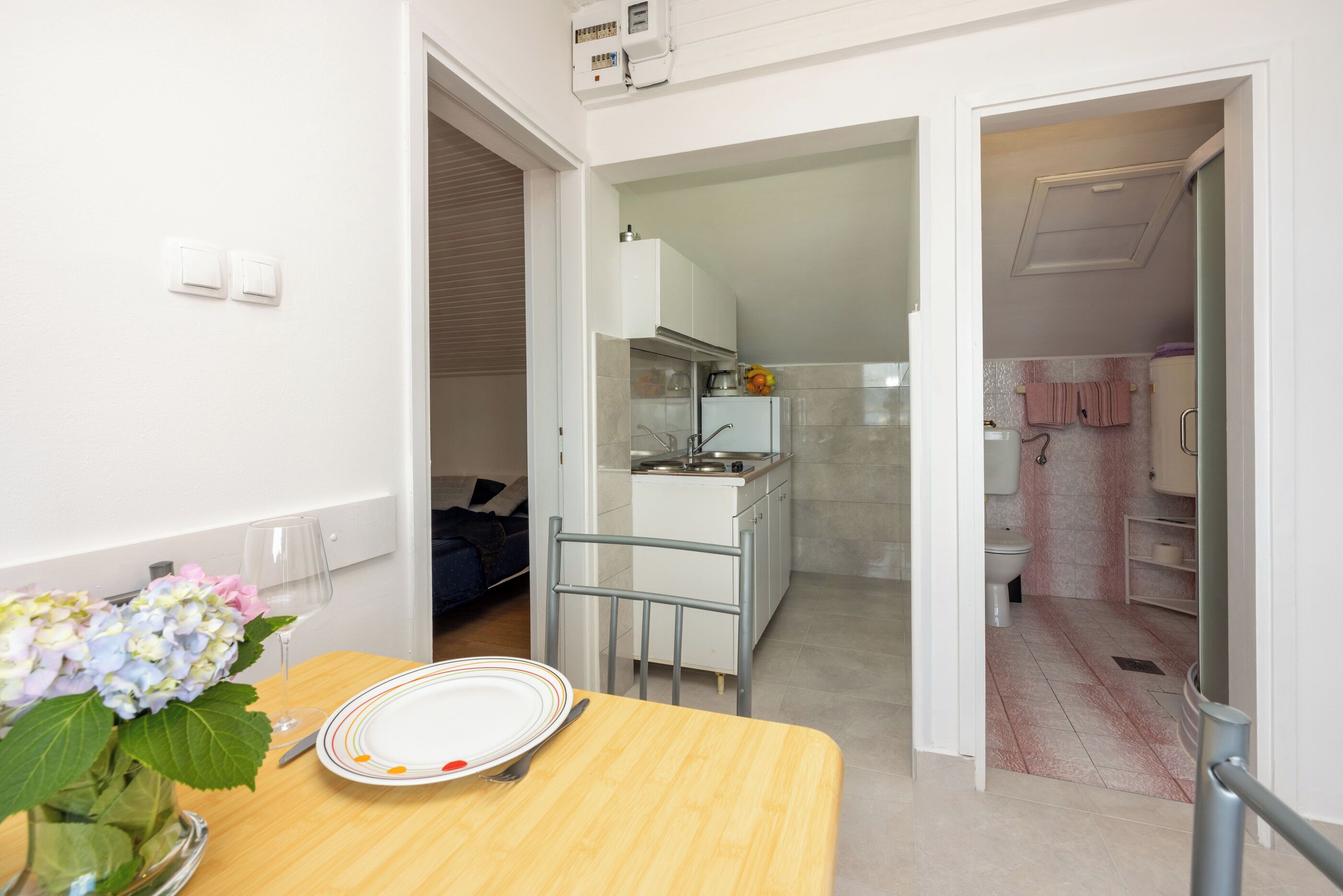 A compact kitchen with a dining area, a small sink, and a refrigerator.