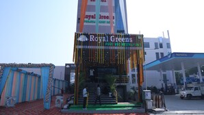 A hotel entrance with a sign for 'Royal Greens Premium Luxury Hotel' and a 'Royal Greens Pure Veg Restaurant' sign. - Royal Greens (Sikar)