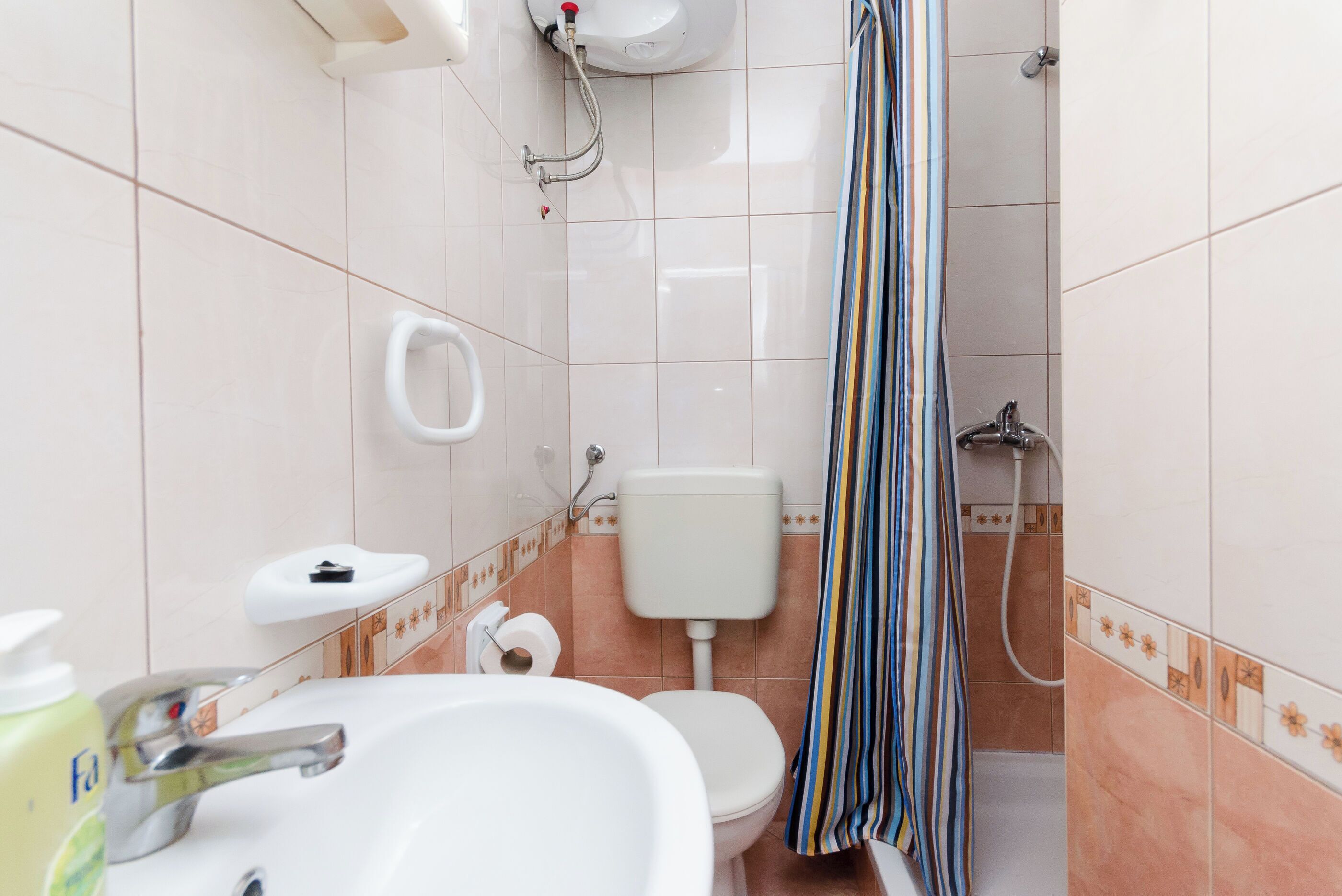 Een badkamer met een wastafel, toilet en douche.