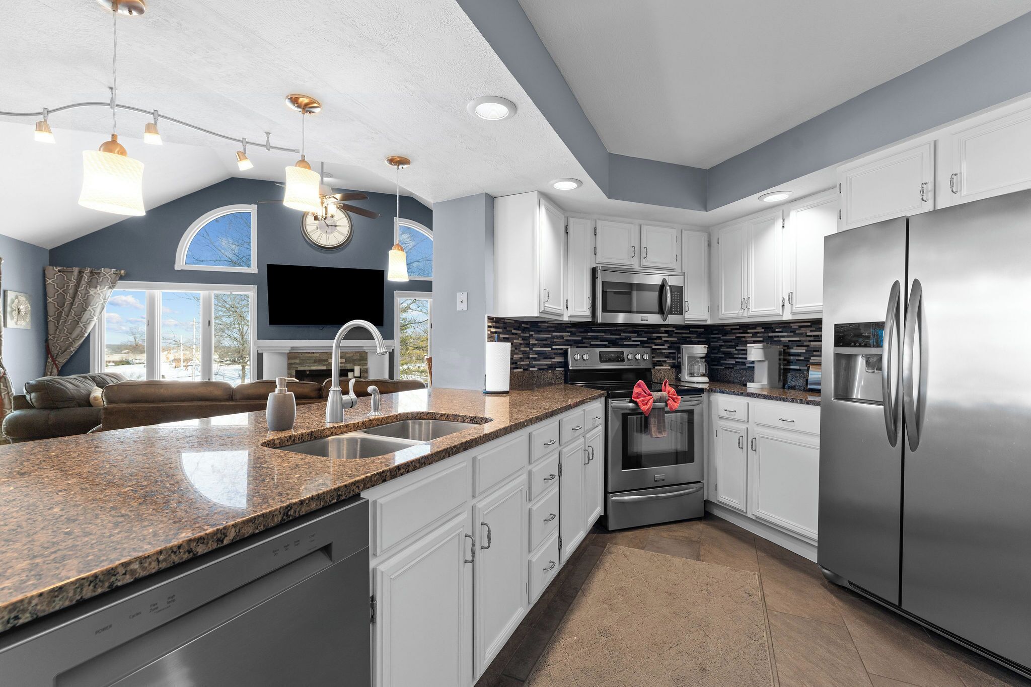 A modern kitchen with granite countertops, stainless steel appliances, and a large island.